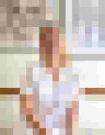 Dr. Ulrike Mack in weißer Kleidung, lächelnd in der Arztpraxis, umgeben von Bildern.